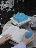 Load image into Gallery viewer, Lifestyle presentation of Wave to the Life mousse cake during a relaxing reading moment.